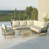 Outdoor rattan sofa set with beige cushions and armchair on terrace overlooking green fields