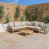 Beige outdoor corner sofa set with wooden coffee table on a patio, surrounded by greenery