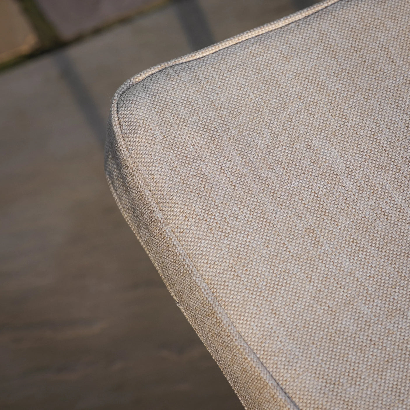 Close up of beige textured sofa cushion corner with neat piping detail