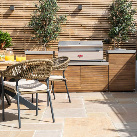 Outdoor rattan dining chairs and wood effect garden kitchen with stainless steel barbecue