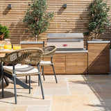 Outdoor rattan dining chairs and wood effect garden kitchen with stainless steel barbecue