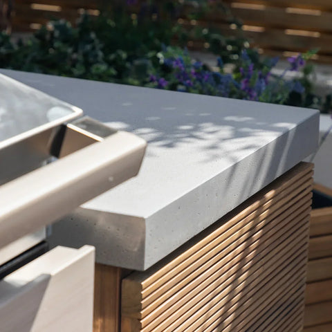 Close view of outdoor kitchen countertop with concrete top and wooden slatted panel
