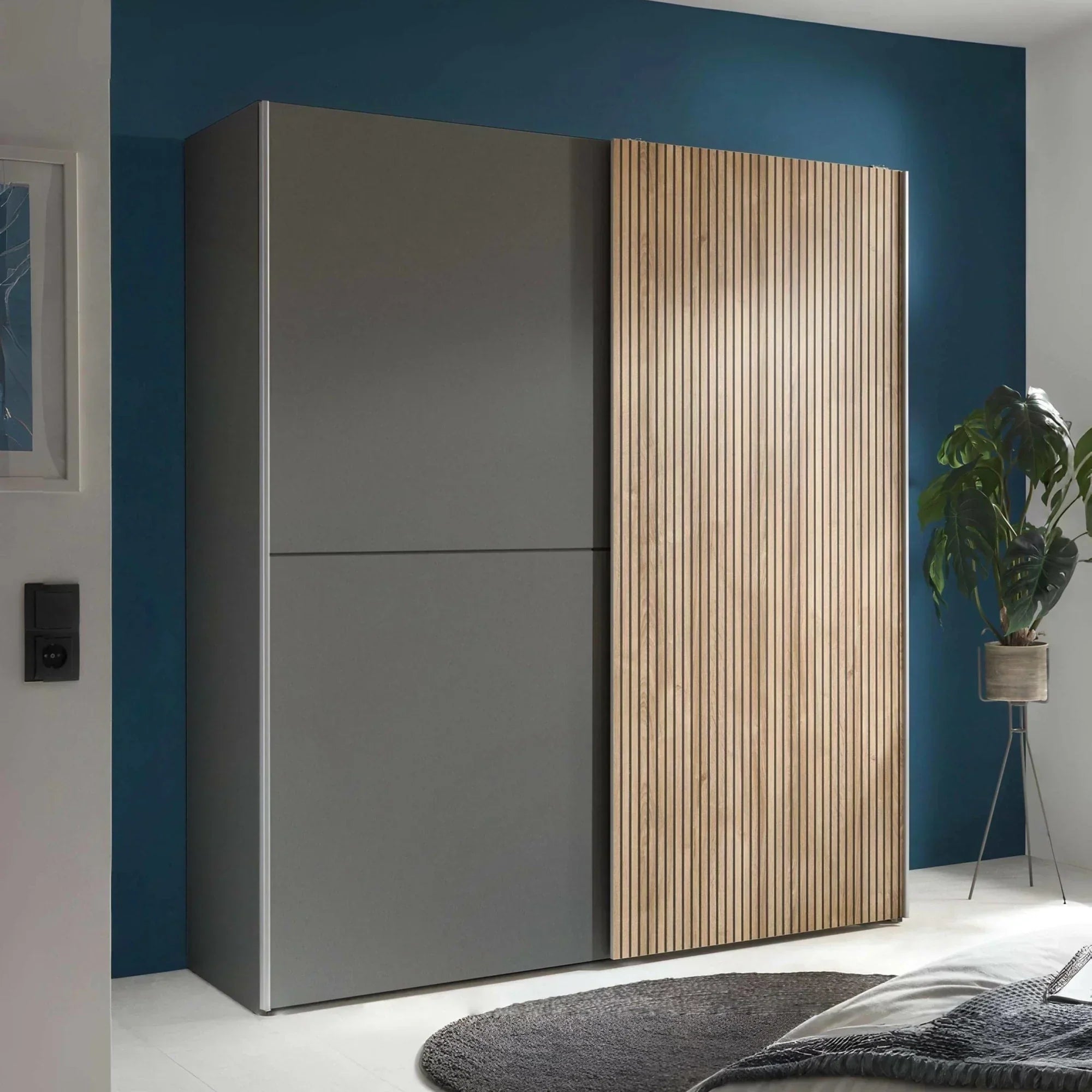 Modern wardrobe with grey doors and vertical wood slat sliding door in bedroom setting