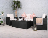 Black rattan garden furniture set with cream cushions, coffee table, and decorative pillows