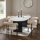 Modern dining table with six cream fabric chairs on rug in bright dining room
