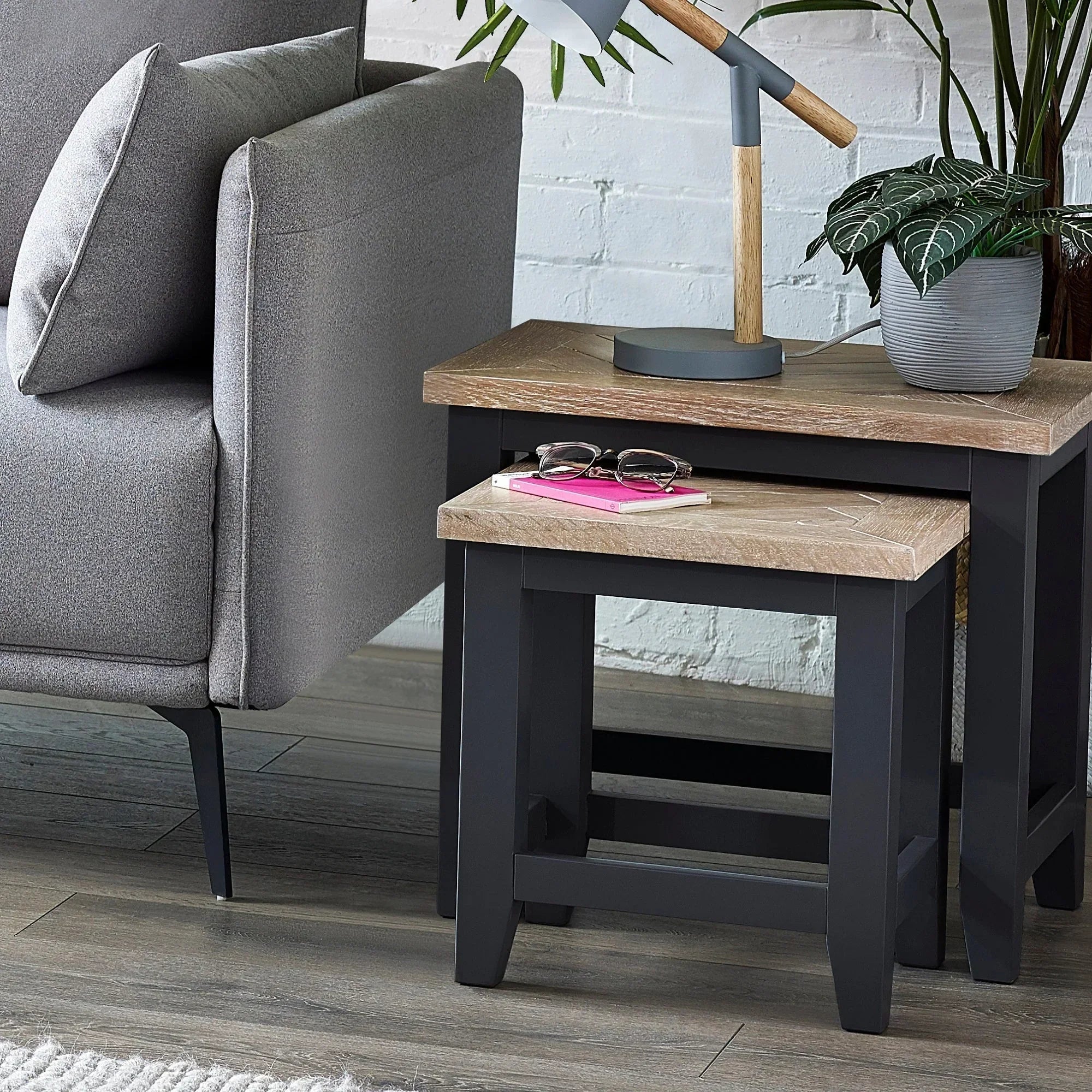 Bordeaux nest of tables with oak tops and black legs beside grey sofa in living room