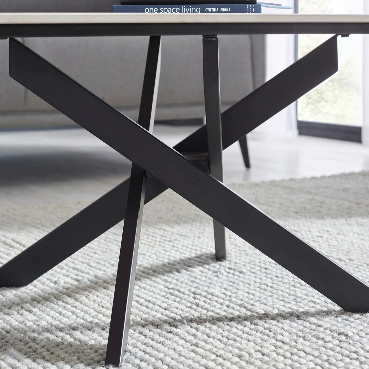 White marble coffee table close-up with black metal legs on textured rug