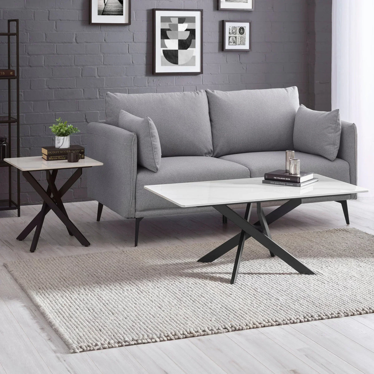 Grey fabric sofa with marble top coffee table and side table on light rug in modern living room