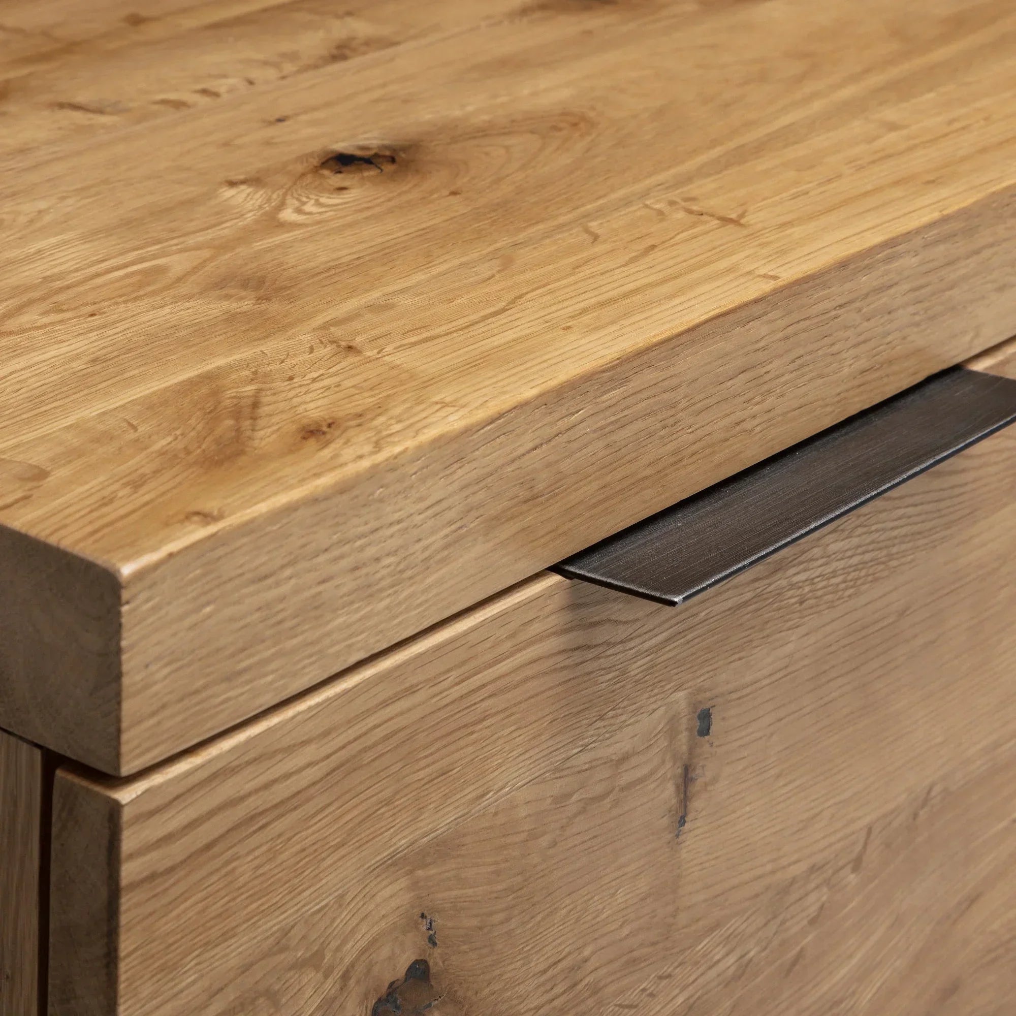 Close-up of oak TV unit corner with drawer handle and wood grain detail