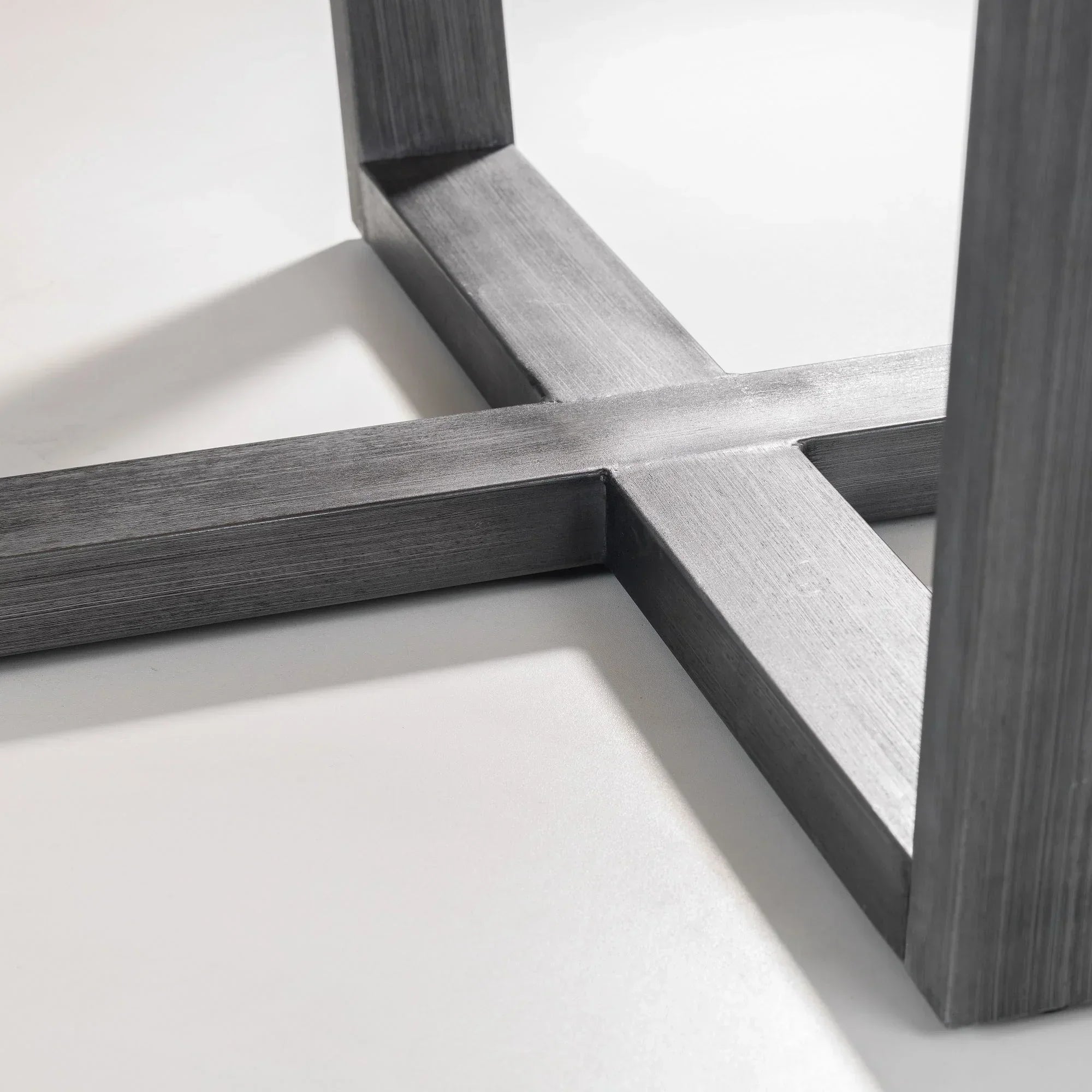 Close up of Brooklyn round table metal cross base in brushed finish