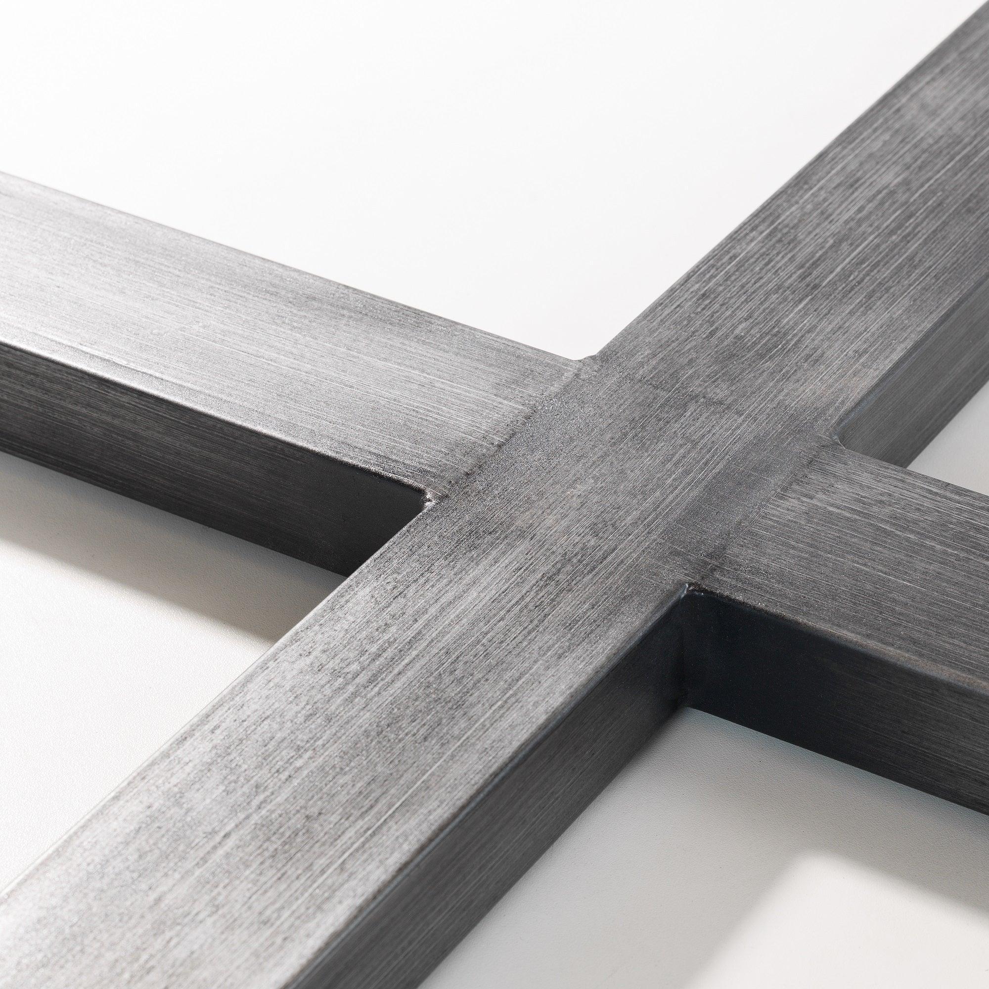Close-up of black metal cross base on oak dining table