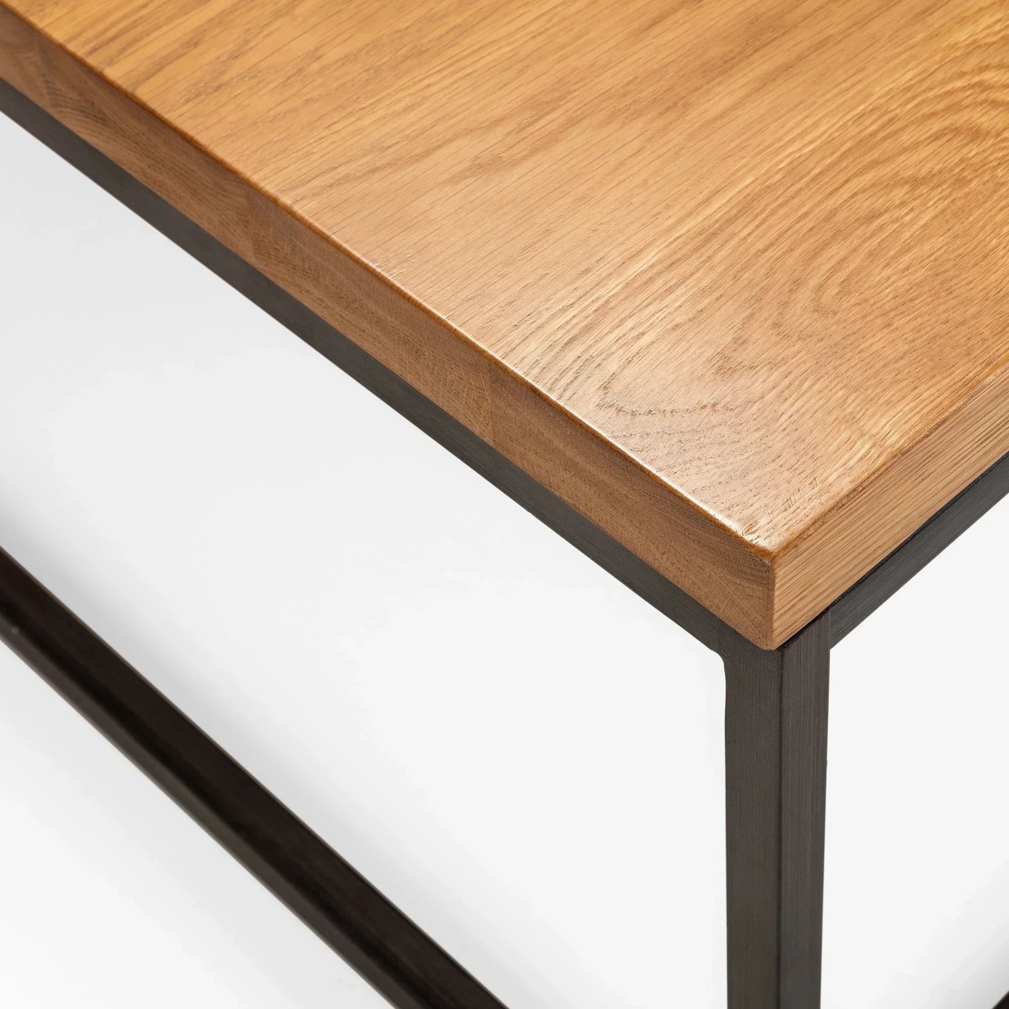 Close-up of coffee table with oak wood top and black metal frame corner detail