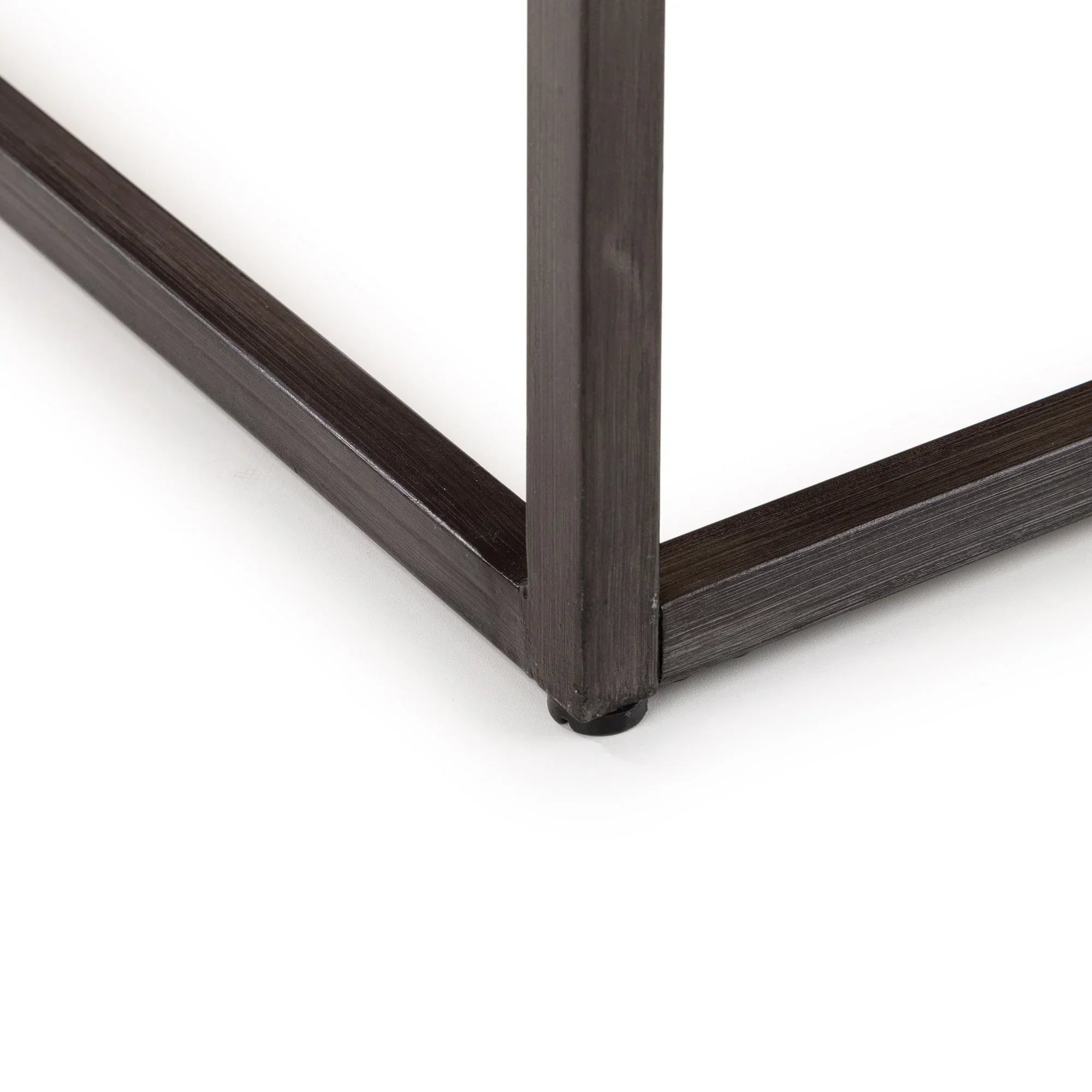 Close-up of metal coffee table leg with dark brushed finish on white background