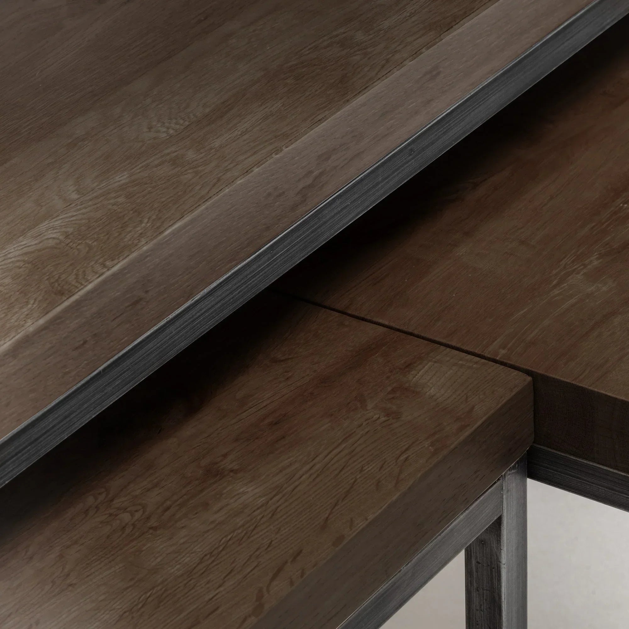 Closeup of dark oak nesting coffee tables showing wood grain and metal frame details