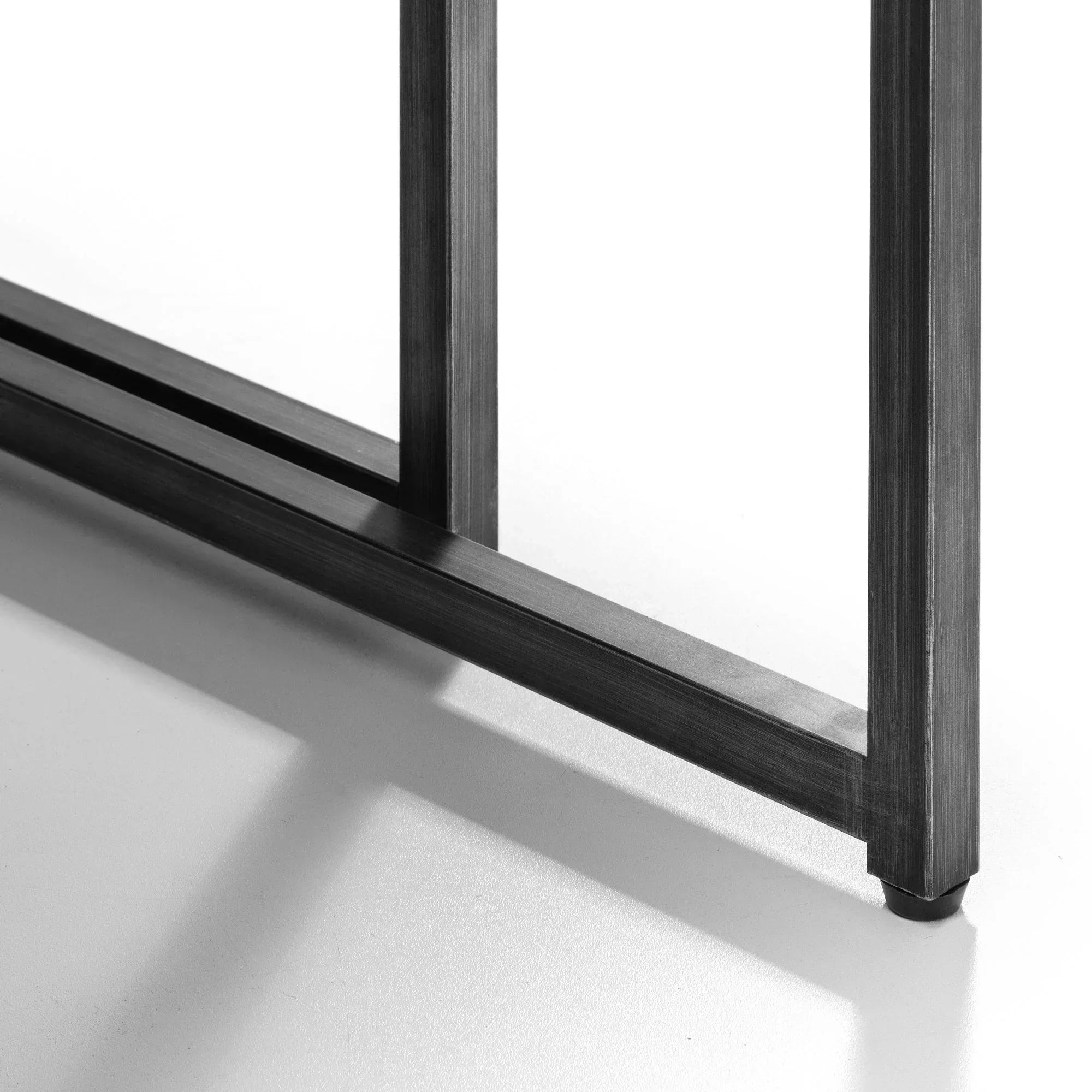 Close-up of nesting coffee table black metal base on light surface