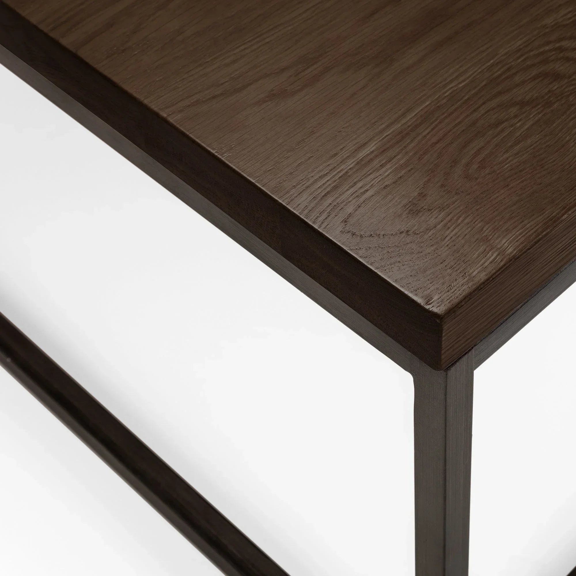 Dark oak square coffee table corner with metal frame, close-up of tabletop wood grain