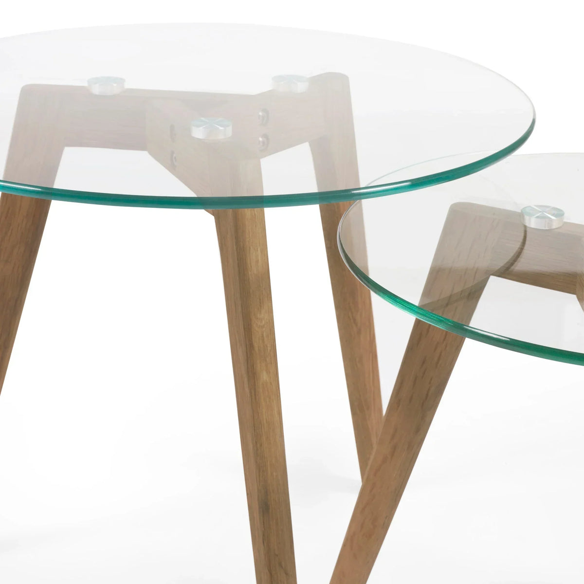 Round glass nest of tables with wooden legs close up