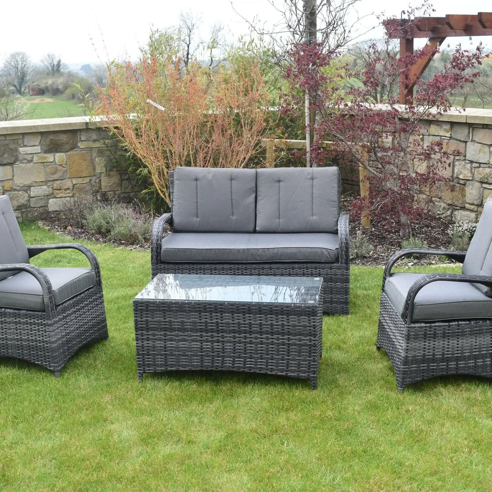 Grey rattan Barcelona sofa set with cushions and glass table on garden lawn