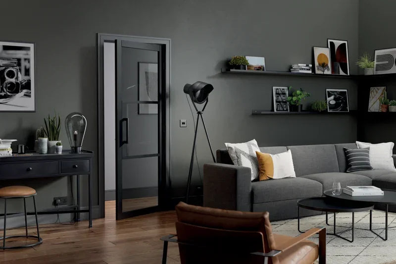 Black Tribeca glazed door with tinted glass in modern living room with grey sofa and wood floor
