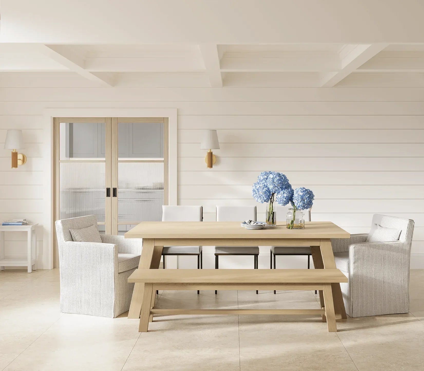 Blonde oak Sutton reeded glazed dining table with bench, armchairs, and blue hydrangeas