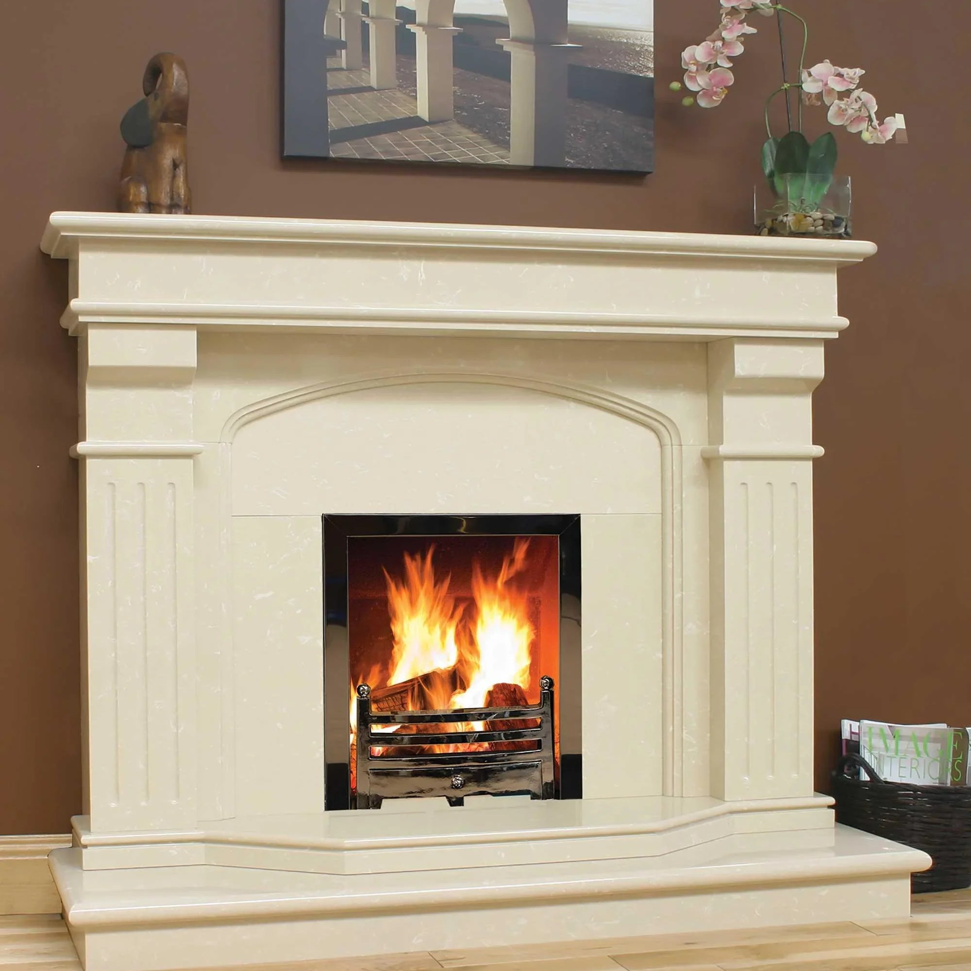 Ivory marble fireplace surround with burning fire and chrome grate in modern living room