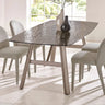 Rectangular glass dining table with textured top and beige upholstered chairs in bright room