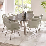 Glass top dining table with six light grey upholstered chairs in modern dining room
