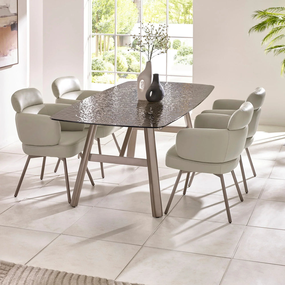Modern dining table with textured glass top and six cream upholstered dining chairs