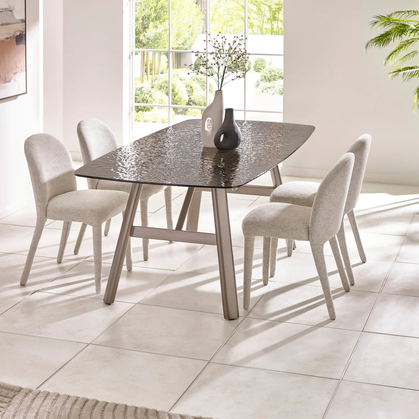 Glass dining table with textured top and four cream upholstered chairs in modern room
