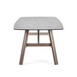 Rectangular dining table with textured light grey top and bronze metal legs, front view