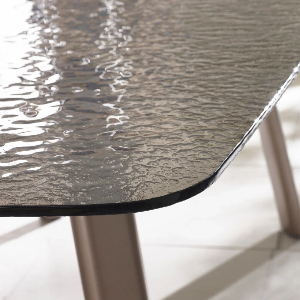 Closeup of textured glass garden table top with metal legs on tiled floor