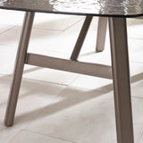 Close view of glass top dining table with metal legs on tiled floor