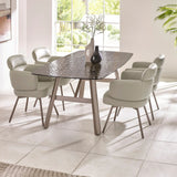 Glass top dining table with four beige upholstered chairs in bright modern dining room