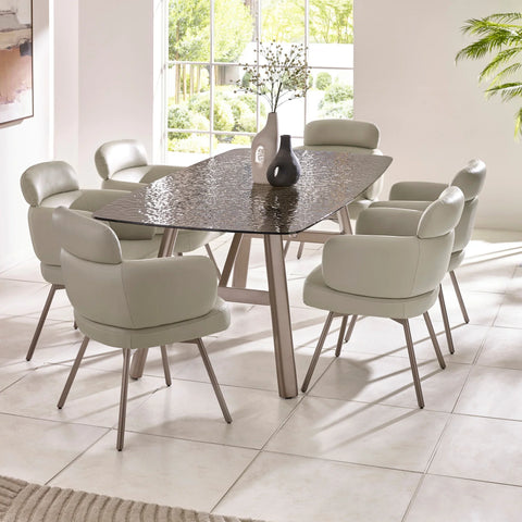 Modern dining table with textured glass top and six beige upholstered dining chairs