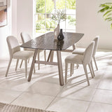 Glass dining table with four cream upholstered chairs in a bright modern dining room