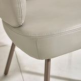 Close-up of beige faux leather dining chair seat with stitched detail and metal leg