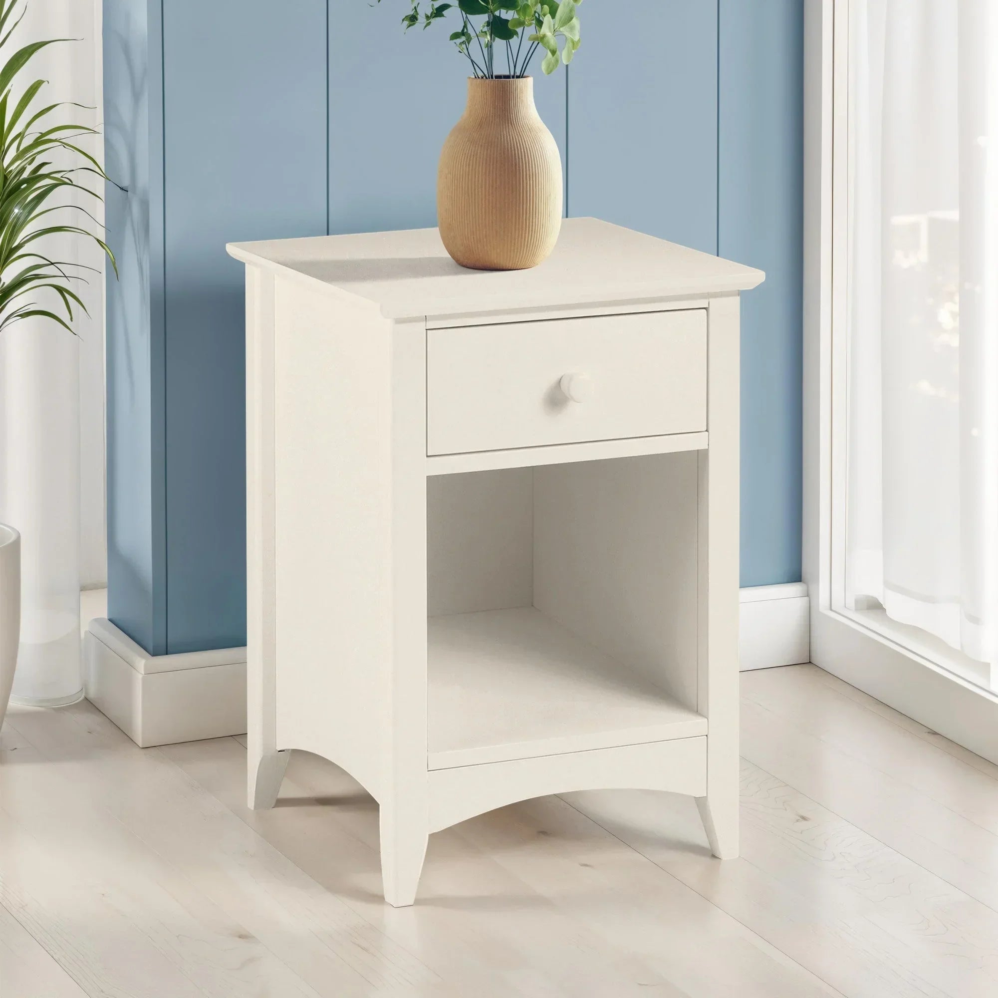 White bedside table with single drawer and open shelf in modern room