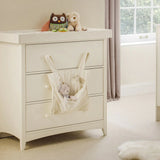 Cream changing station with drawers, soft toys on top, nursery storage pocket attached