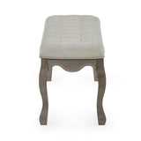 Side view of button tufted beige fabric bench with curved natural wood legs on white background