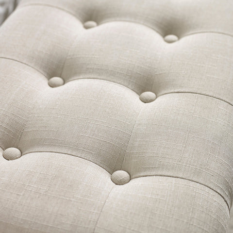 Close up detail of beige button tufted fabric upholstery with subtle linen texture on bench seat