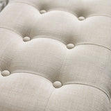 Close up detail of beige button tufted fabric upholstery with subtle linen texture on bench seat