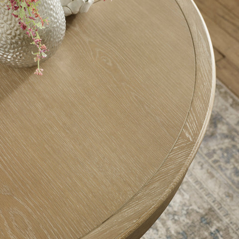 Close-up of light brown wooden round table edge showing grain and smooth finish
