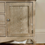 The Camille French Style 2 Door 2 Drawer Sideboard features a limed oak finish with a textured wood grain, elegantly curved legs, and a classic design suitable for a stylish living room or dining area