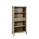 The Camille French Style Tall Bookcase features a limed oak finish with two drawers and three open shelves, elegantly designed with curved legs, perfect for displaying books and decor in a stylish living space