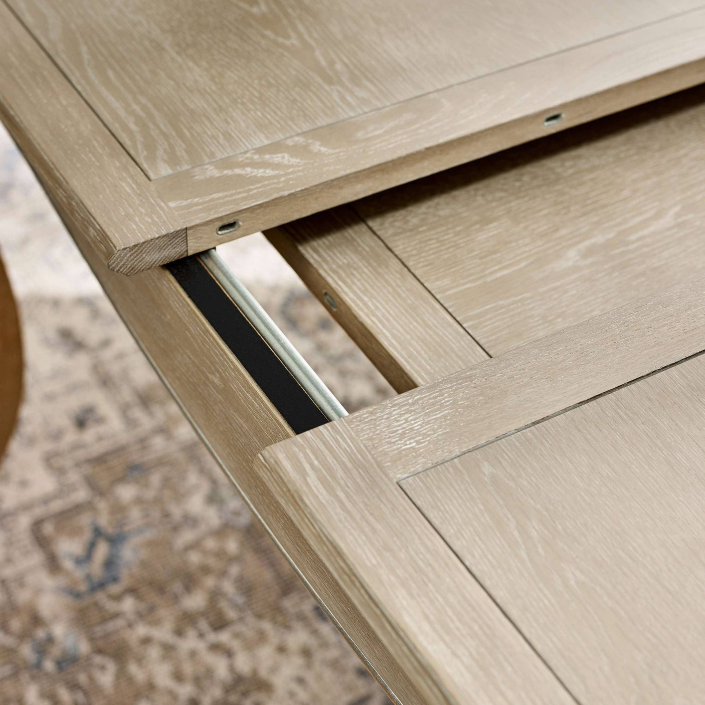 Close-up detail of the Camille French Style Rectangular Extending Dining Table in limed oak, showcasing the smooth finish and extension mechanism