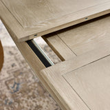 Close-up detail of the Camille French Style Rectangular Extending Dining Table in limed oak, showcasing the smooth finish and extension mechanism
