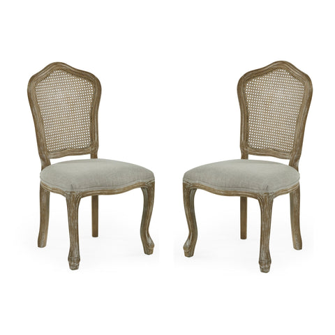 Pair of beige upholstered rattan dining chairs with carved light wood frames on white background