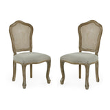 Pair of beige upholstered rattan dining chairs with carved light wood frames on white background