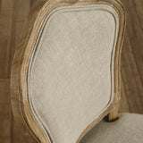 Close-up of beige upholstered dining chair backrest with weathered natural wood frame detail
