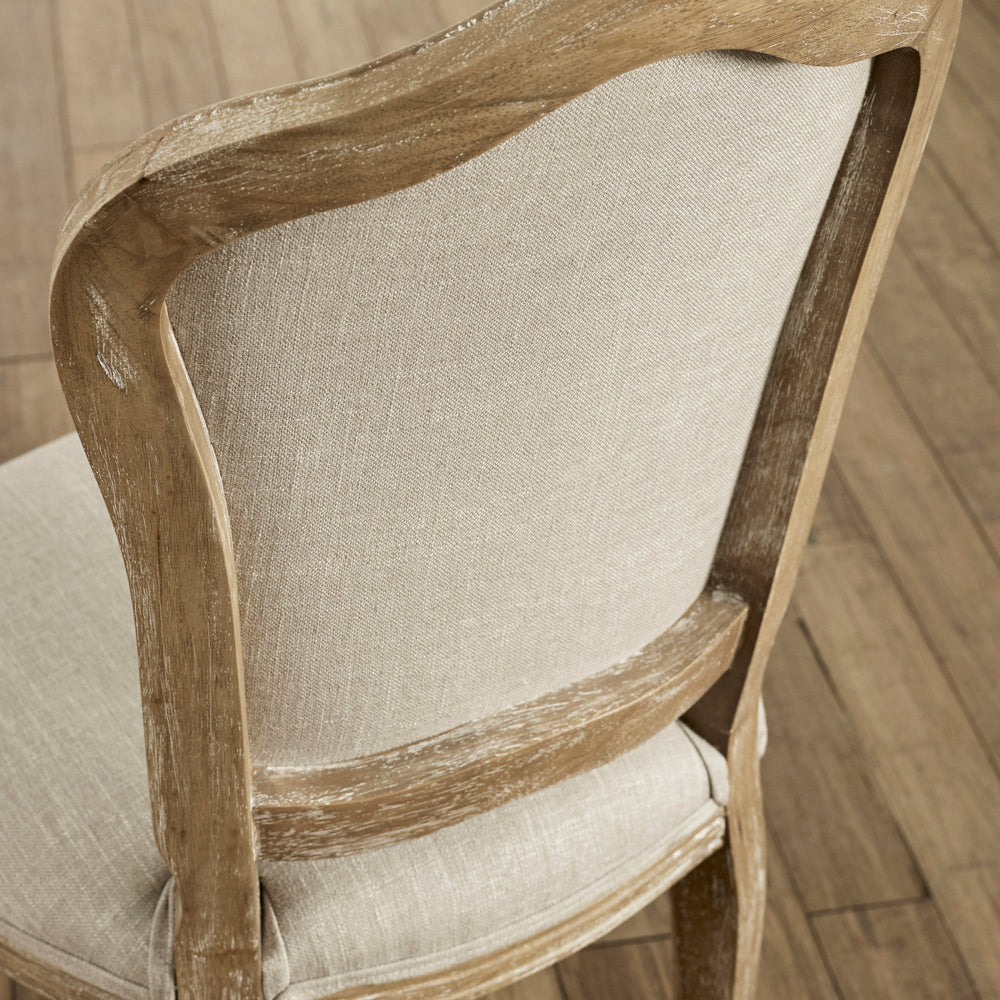 Close-up of beige upholstered backrest with wooden frame on dining chair showing fabric texture and finish.
